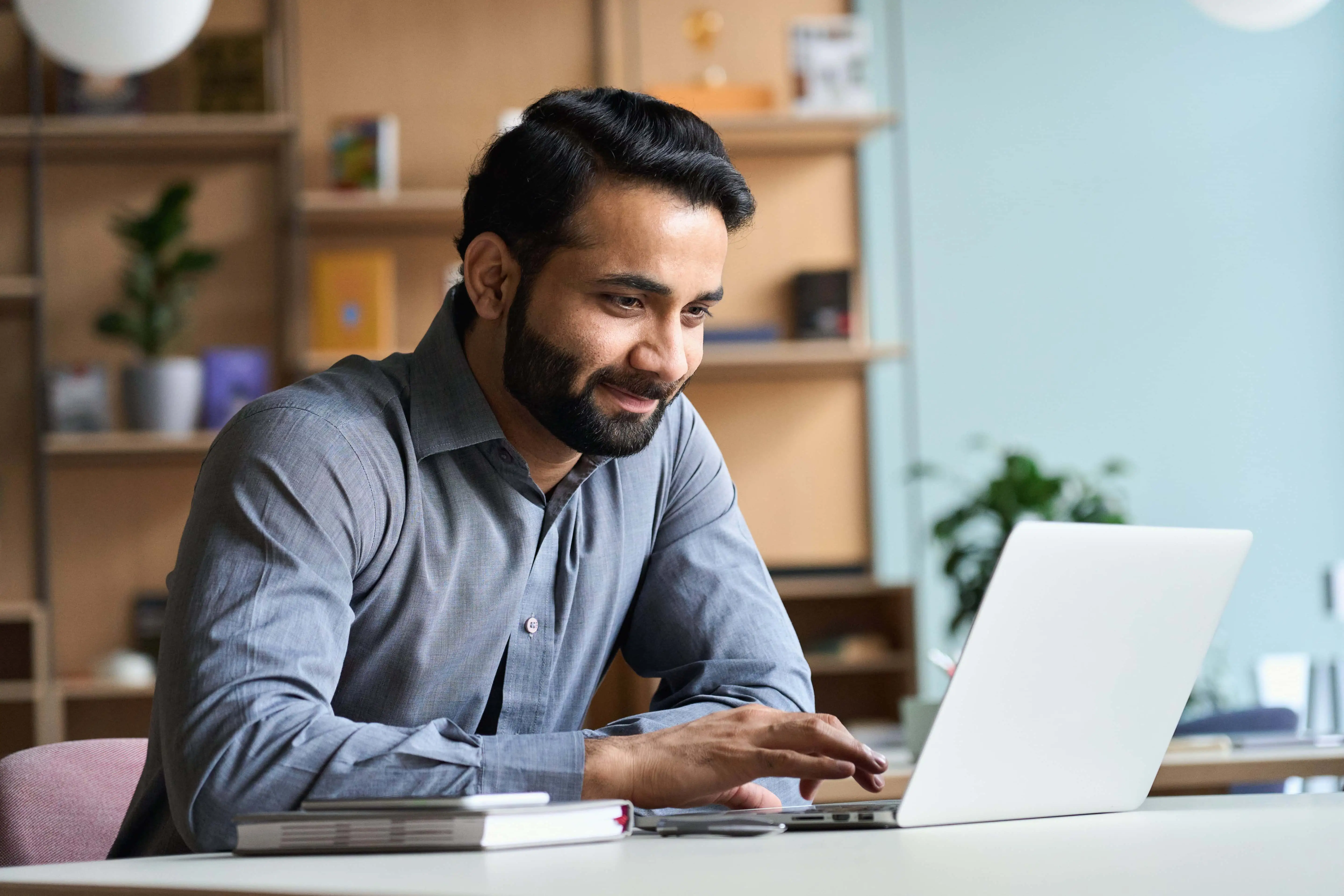 a man sit and smiling in front of laptop a man sit and smiling in front of laptop